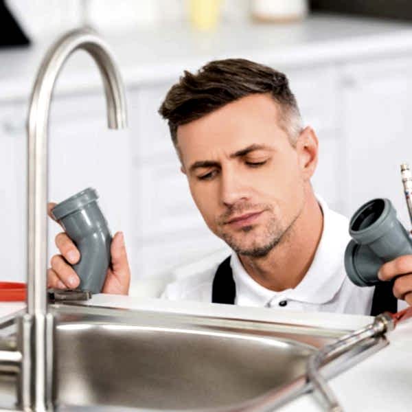 thoughtful-adult-repairman-holding-pipes-and-tools-resize.jpg
